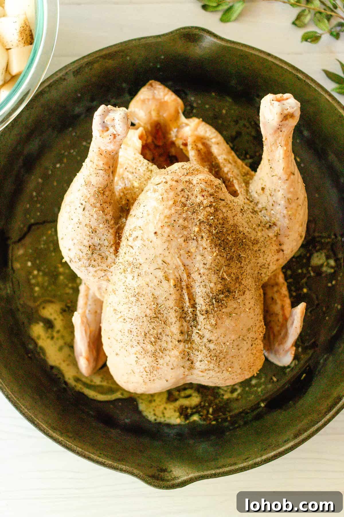 Pour the melted butter over the chicken in the cast iron skillet.
