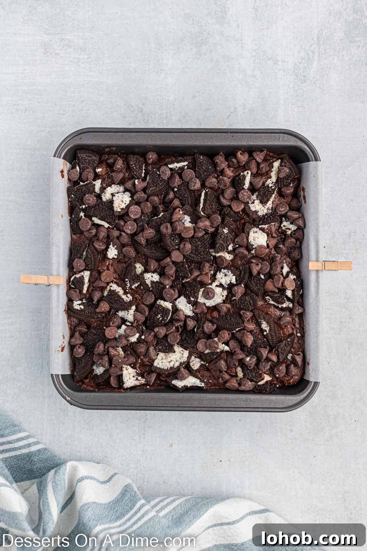 Fudgy Oreo Brownies Recipe with Creamy Cookie Filling 8 Remaining batter poured on top. Then crushed cookies and chocolate chips added.