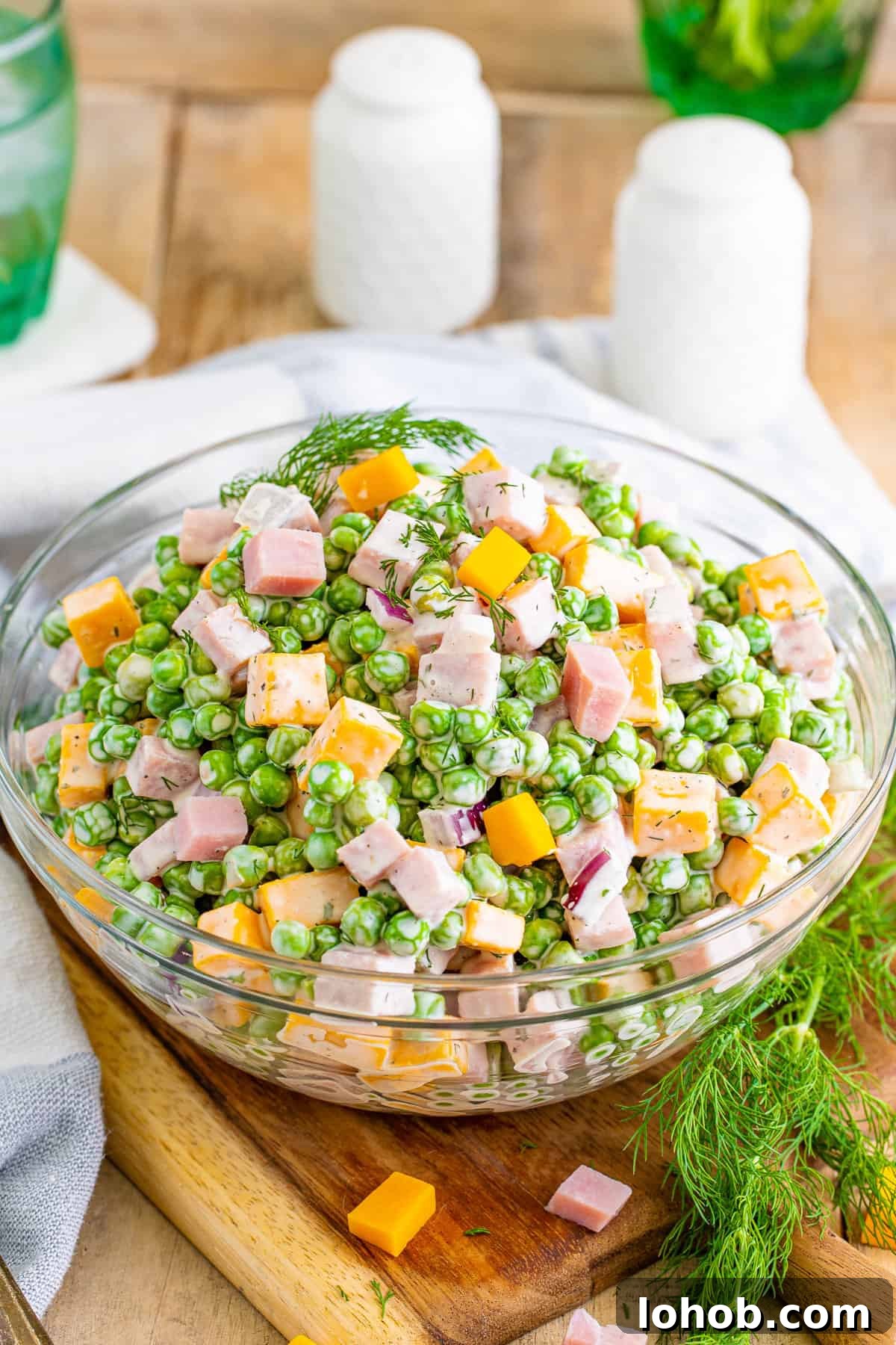 Ham and pea salad with sweet green peas, cubed ham, cubed cheese, red onion, fresh dill, all tossed in a creamy dressing.