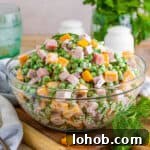 Ham and pea salad with cheese, red onion, and a creamy dressing.