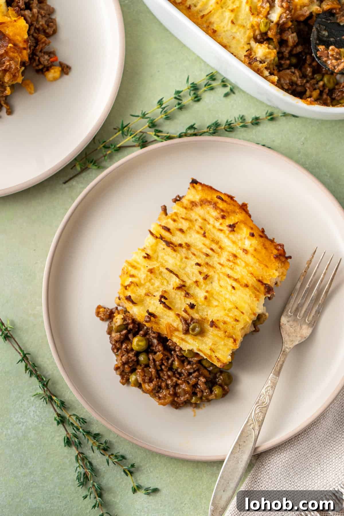 Classic Cottage Pie Recipe with Savory Beef and Mashed Potato Top 14 A piece of cottage pie served on a plate with a fork.