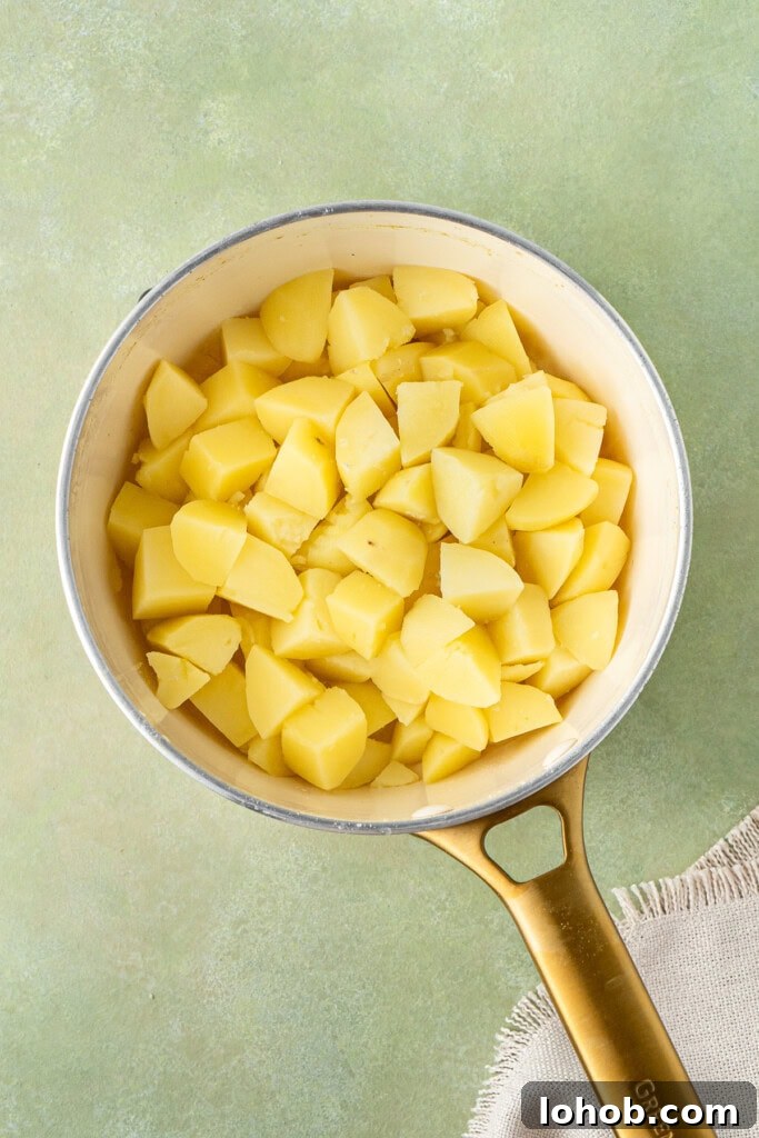 Classic Cottage Pie Recipe with Savory Beef and Mashed Potato Top 9 Boiling potatoes in a pot.