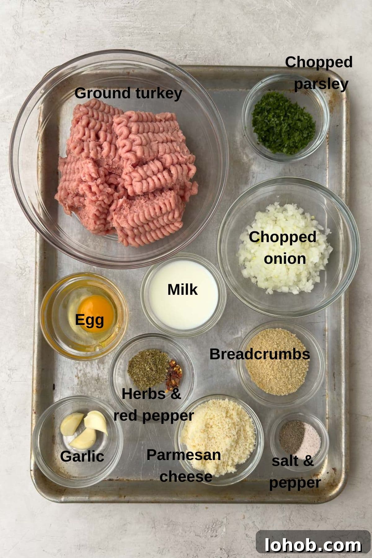 Oven-Baked Turkey Meatballs with Tangy Tomato Sauce 3 Prepped ingredients for meatballs on a sheet tray, ready to start.