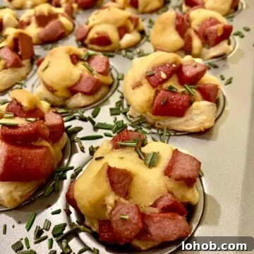 15 Cozy Appetizers for Cold-Weather Entertaining 4 Corn dog nuggets in a mini-muffin pan with rosemary sprinkled on top.