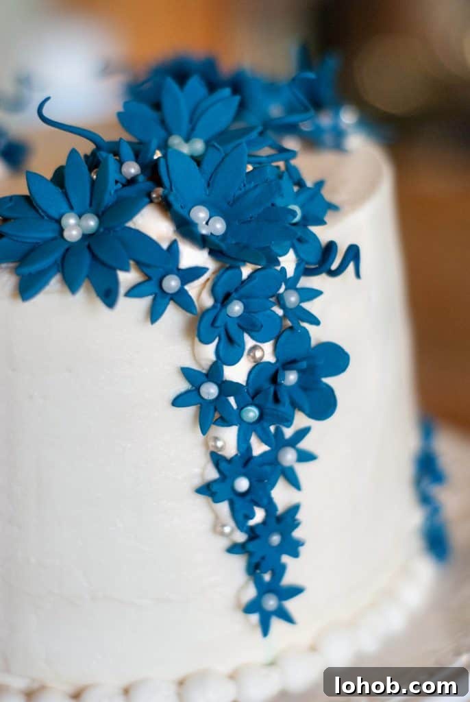 Easy cake with white frosting and decorative blue flowers.