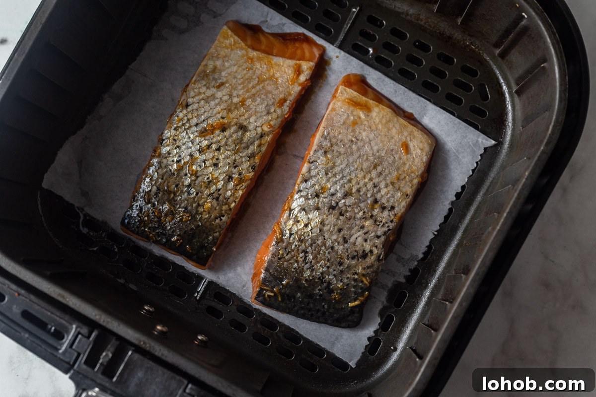 Crispy Air Fryer Teriyaki Salmon 6 placing the salmon skin side up in the air fryer.