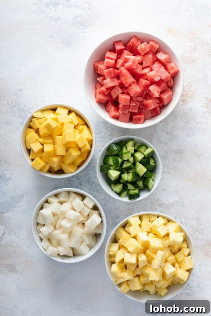 Small bowls of diced fruit, watermelon, mango, cucumber, jicama and pineapple.