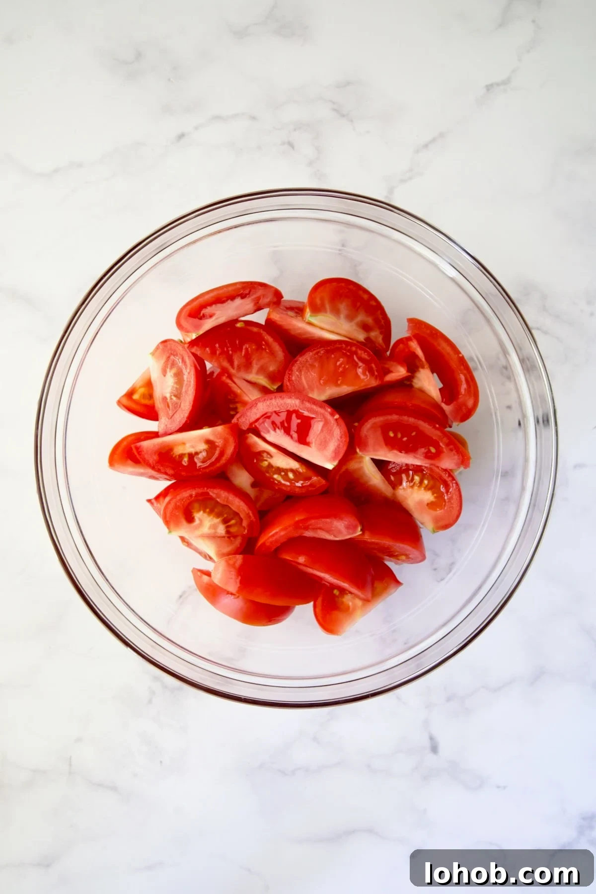 Quick-Pickled Marinated Tomatoes for Fresh Summer Flavor 5 Tomato wedges in glass bowl on marble container.