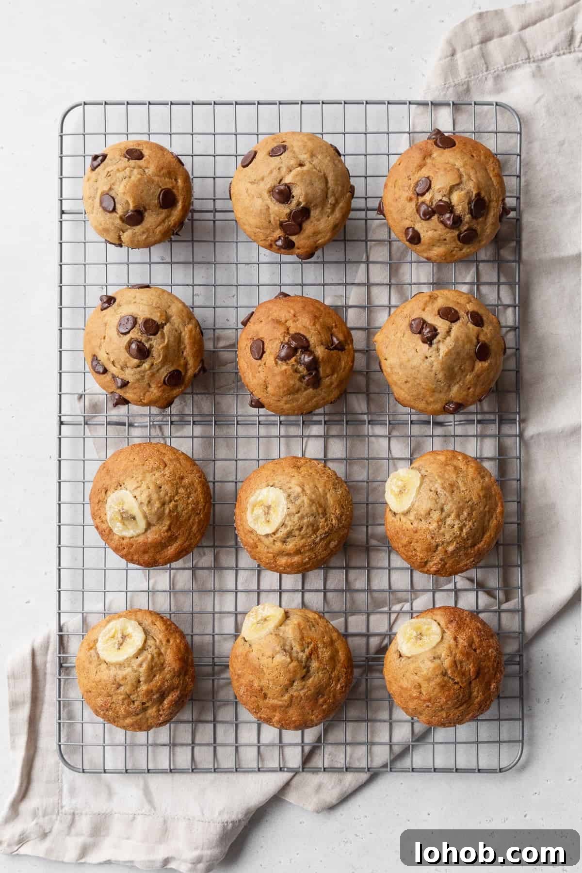 Twelve banana muffins cooling on a wire rack.