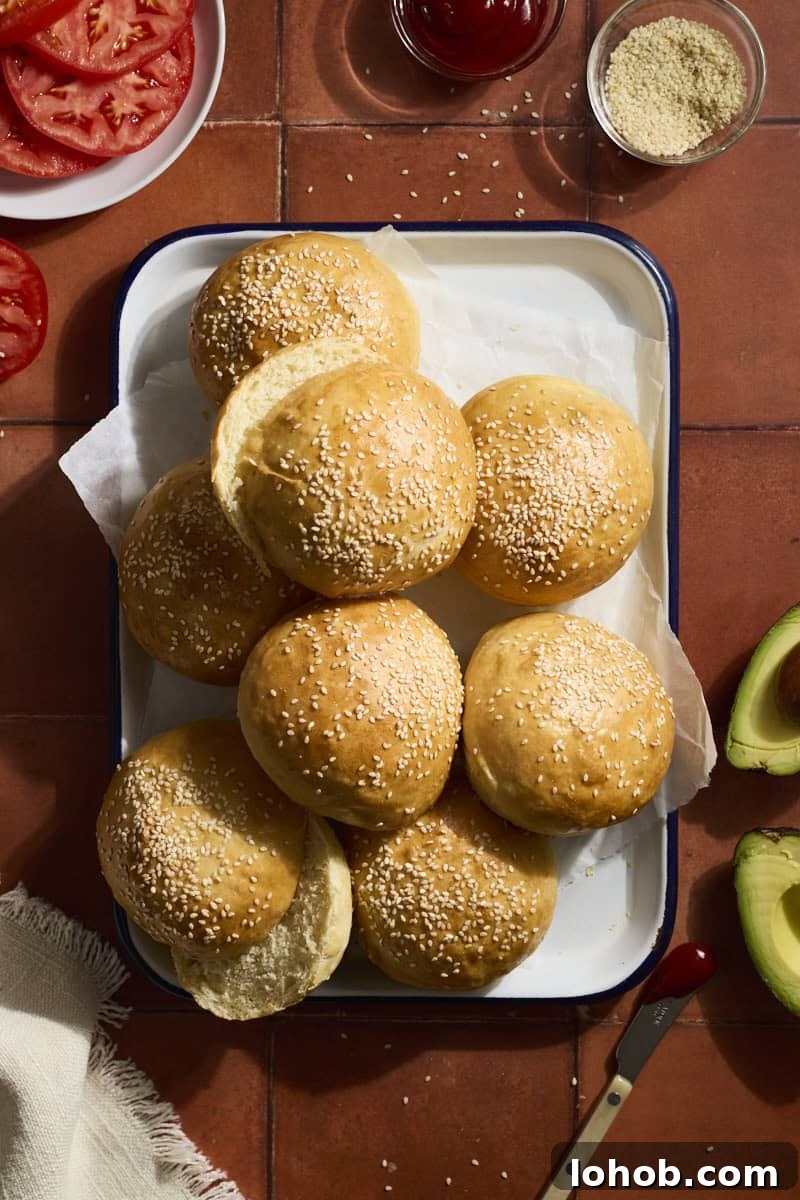Fluffy Sourdough Discard Hamburger Buns You Can Make at Home 2 A stack of Sourdough Discard Hamburger Buns on a white tray.