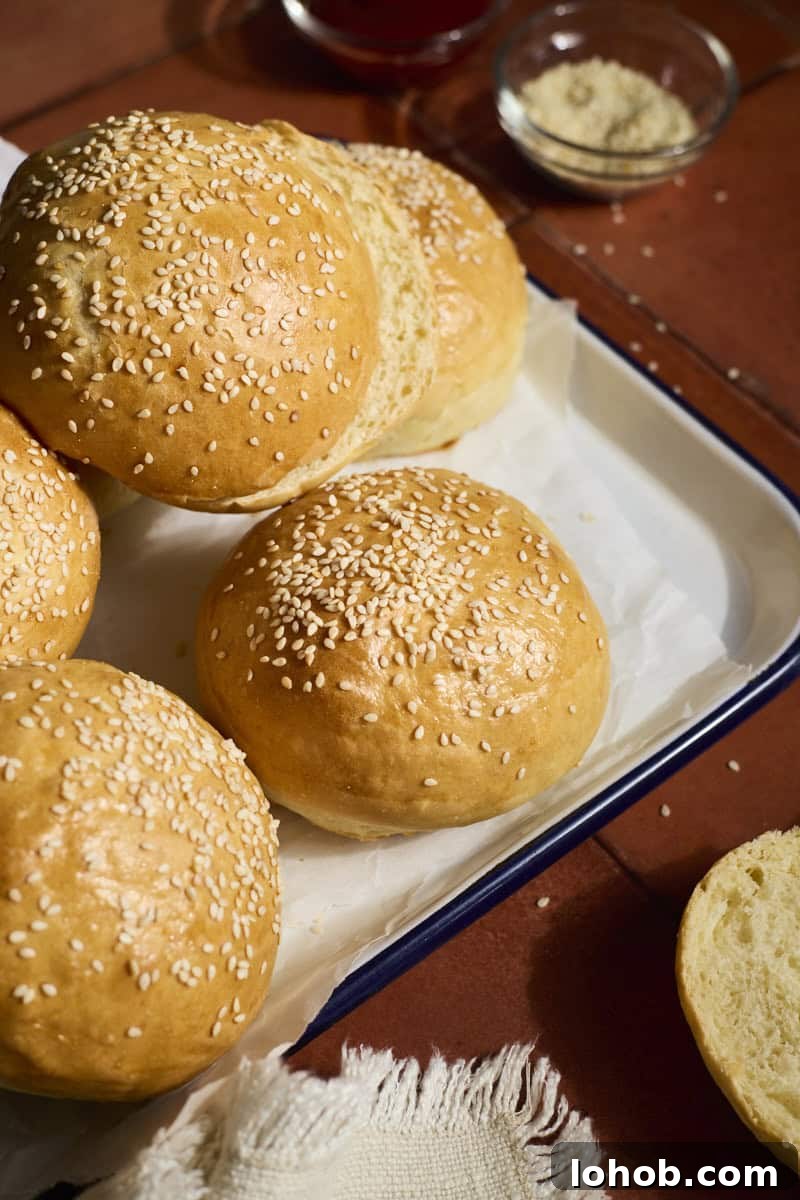 Fluffy Sourdough Discard Hamburger Buns You Can Make at Home 12 A stack of Sourdough Discard Hamburger Buns on a white tray.