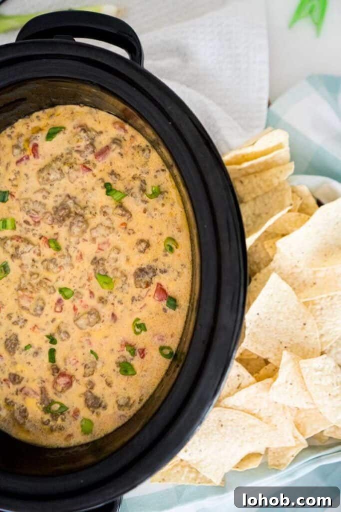 Crock Pot Queso with Beef and Sausage: Slow Cooker Party Dip 2 slow cooker with velveeta spicy cheese dip with sausage and ground beef and tortilla chips