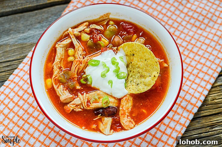 Bowl full of chicken taco soup topped with sour cream and green onions