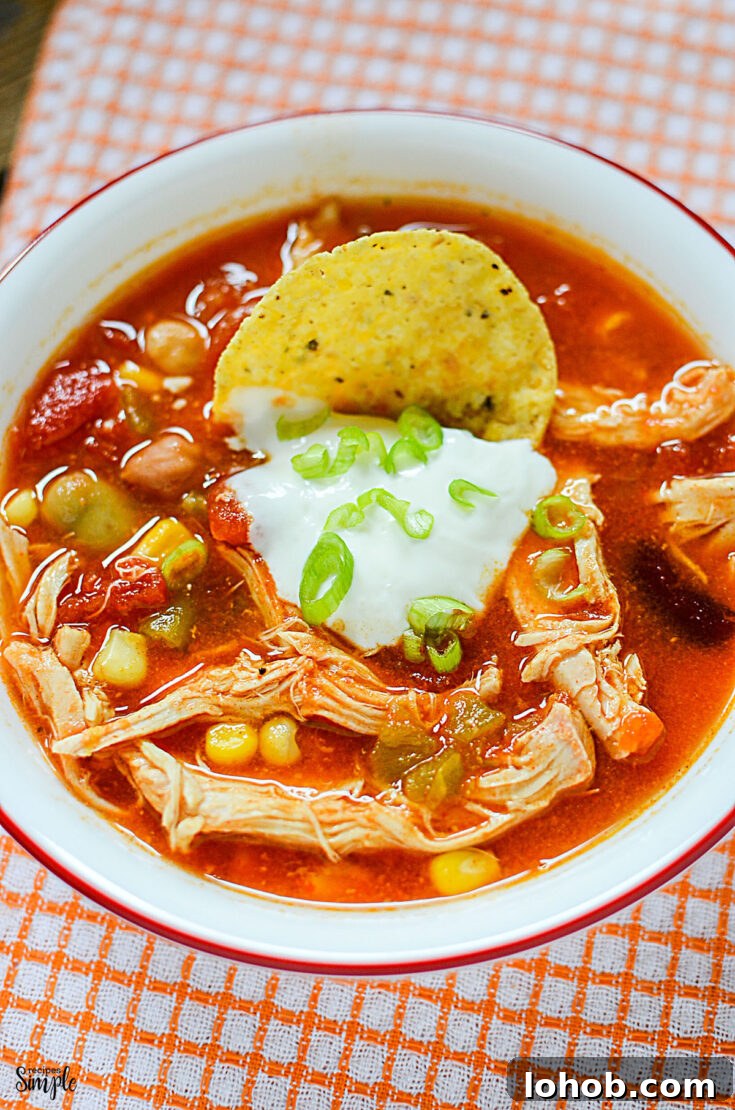 Chicken Taco Soup in white bowl topped with sour cream