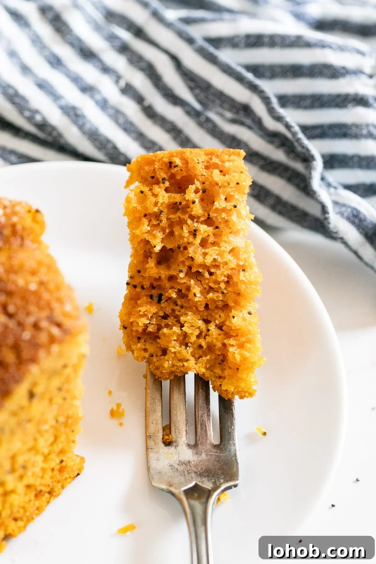 A close up of a bite of poppy seed cake on a fork.