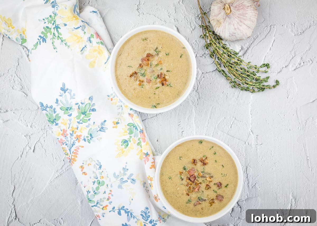 Two bowls of cream of caramelized onion & mushroom soup with garlic and thyme.
