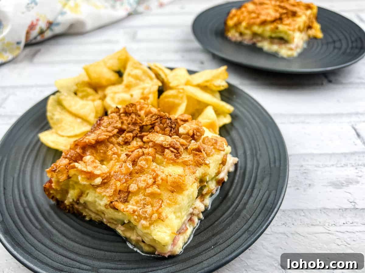 A piece of Cuban sandwich casserole on a plate with potato chips.