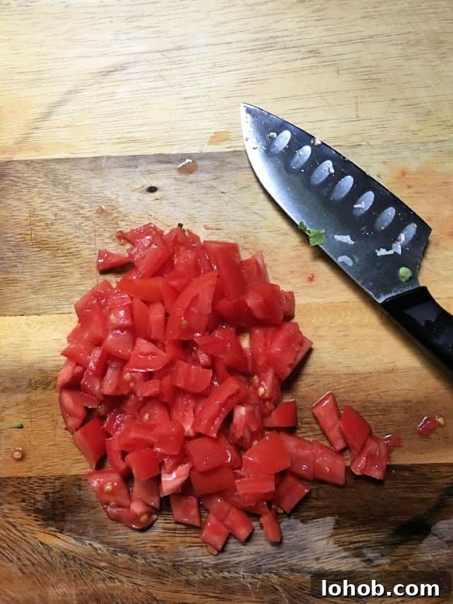 tomato diced with knife on cutting board
