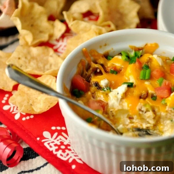 bowl of hot bacon dip with chips and spoon