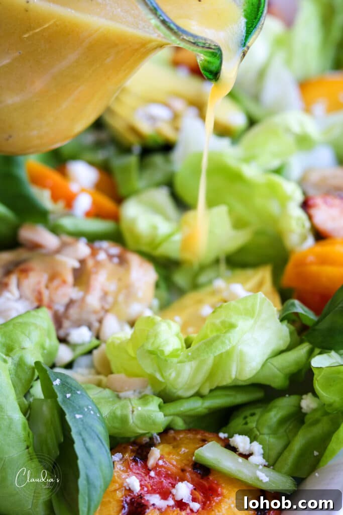pouring peach vinaigrette on salad 
