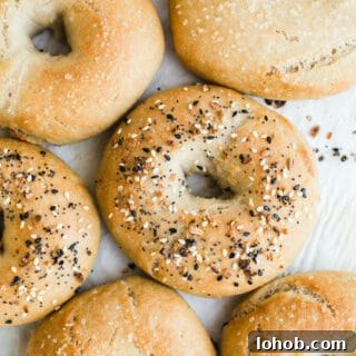 Vegan Gluten-Free Bagel Recipe: Homemade Soft & Chewy Bagels 12 Bagels topped with seeds on a piece of parchment paper.