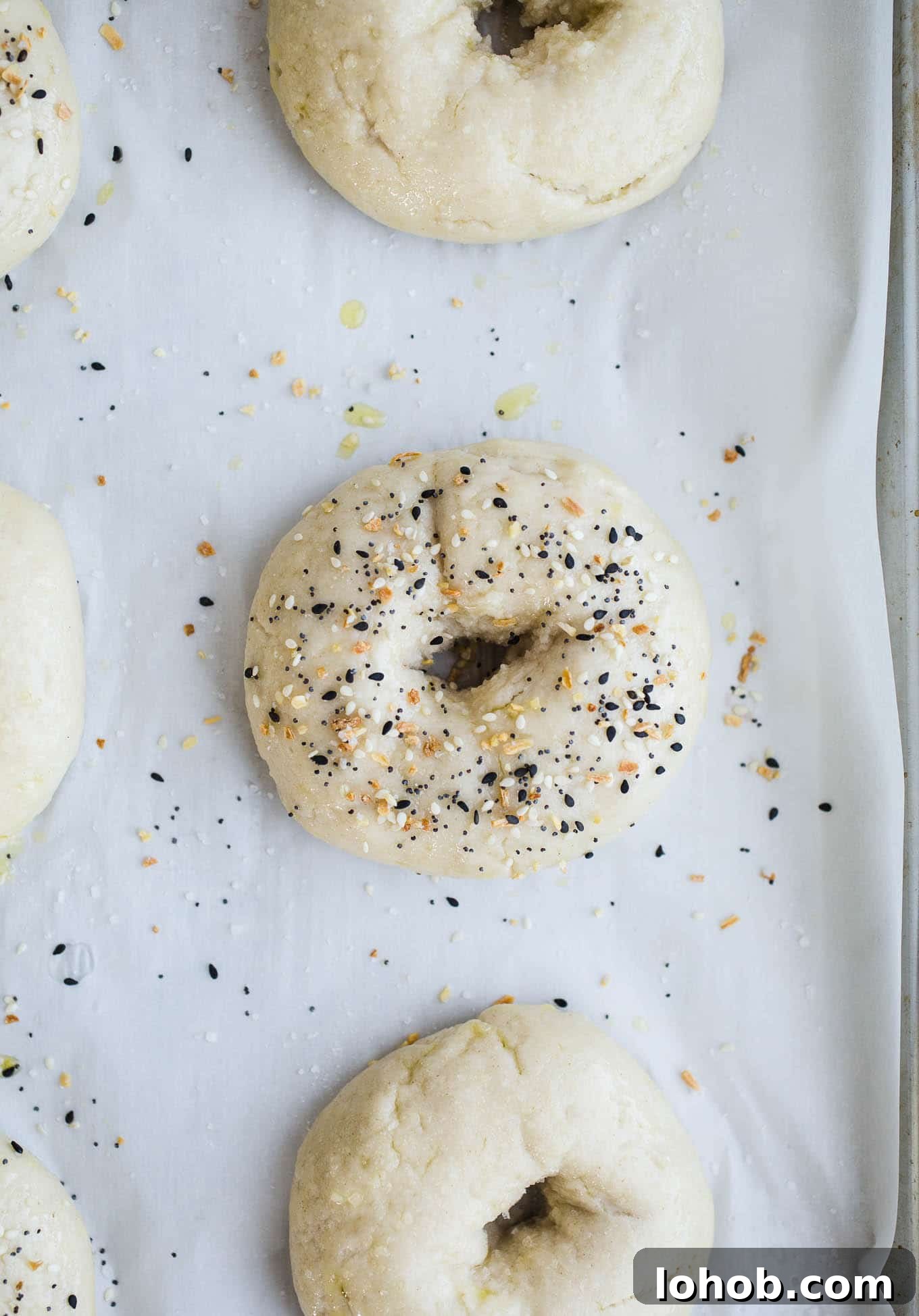 Vegan Gluten-Free Bagel Recipe: Homemade Soft & Chewy Bagels 4 Unbaked bagels with seeds on top.