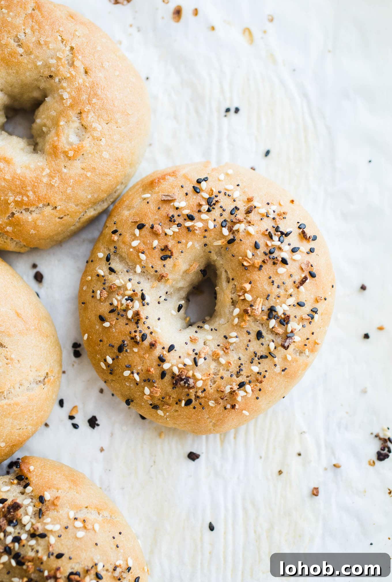 Vegan Gluten-Free Bagel Recipe: Homemade Soft & Chewy Bagels 7 Everything bagels on parchment paper.