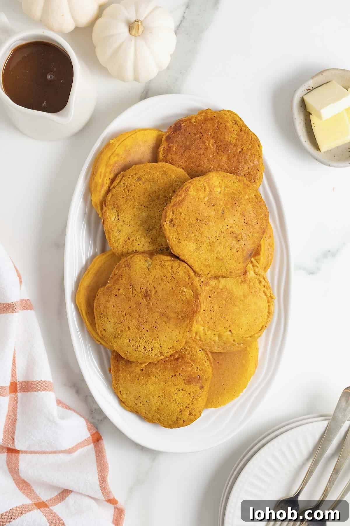 A white oblong plate of pumpkin banana pancakes.