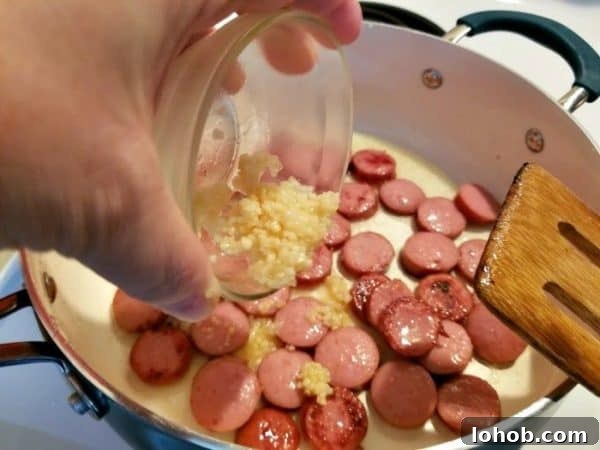 This spicy sausage, bean and pasta soup is the PERFECT weeknight dinner! It's so easy to make and is full of savory spicy delicious flavor! If you're looking for a delicious bean and sausage soup slow cooker recipe - this is the one!