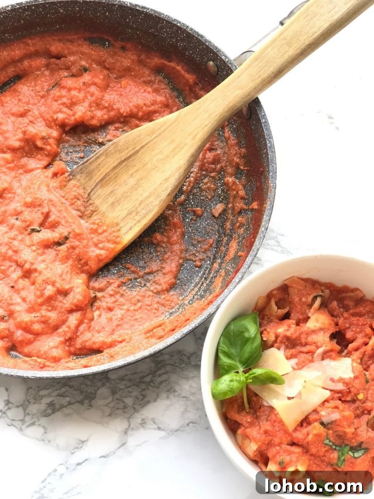 Top Weight Watchers Chicken Recipes: Quick Low-Point Meals 7 A pan of fresh vodka sauce with a wooden spoon sits next to a bowl of penne, vodka sauce and chicken, topped with Parmesan cheese and basil.