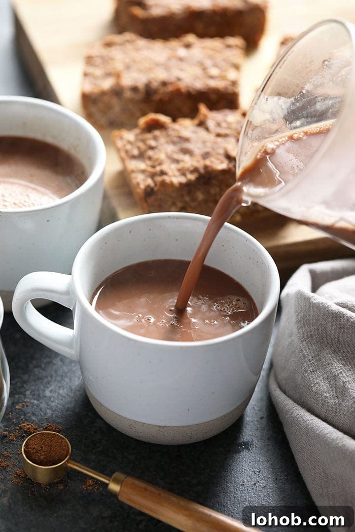 Vegan Chai Hot Chocolate being poured vegan chai hot chocolate being poured in a mug