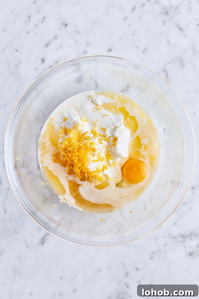 Lemon Poppy Seed Muffins Recipe — Moist, Zesty Morning Treat 6 Milk, sour cream, melted butter, egg, lemon zest, and vanilla extract in glass bowl
