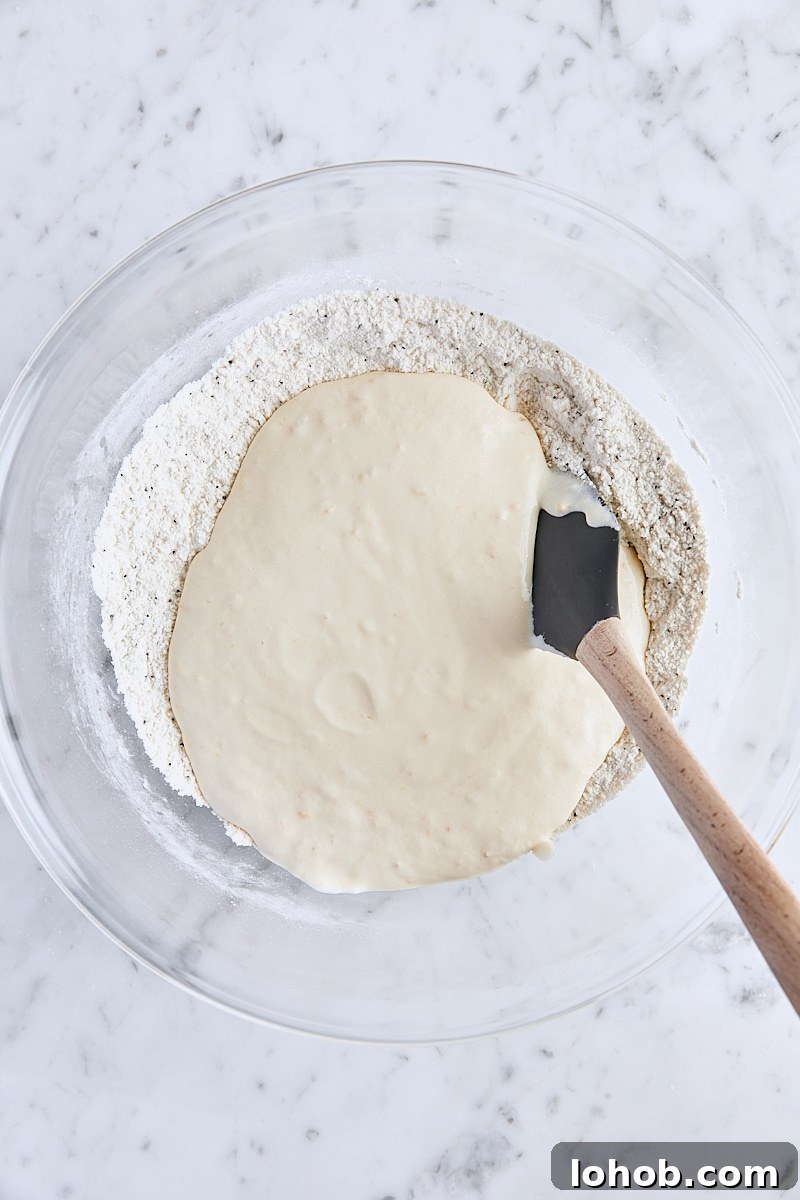 Lemon Poppy Seed Muffins Recipe — Moist, Zesty Morning Treat 8 Sour cream mixture added to flour mixture in large glass bowl