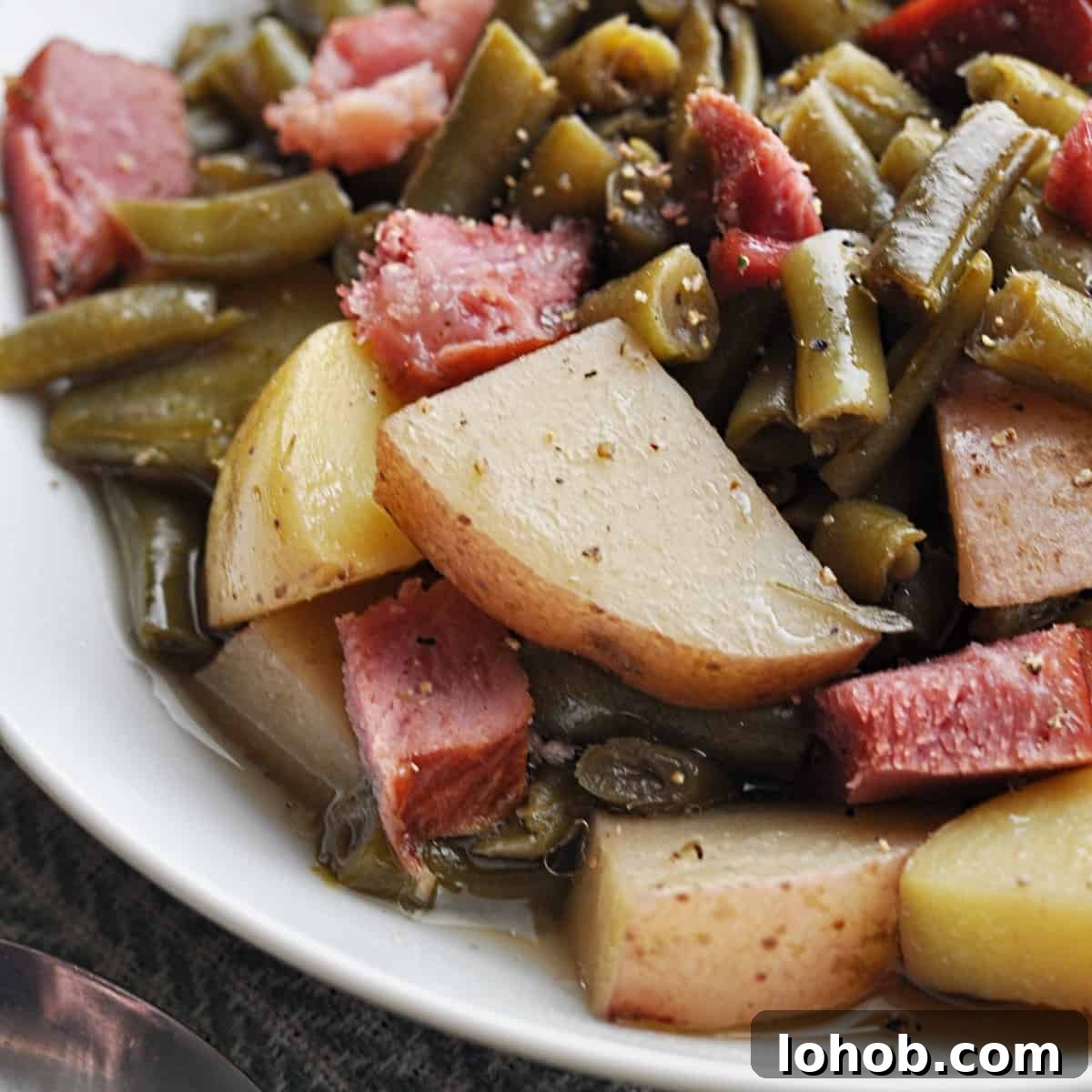 Green beans and potatoes with ham chunks on plate