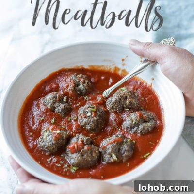 hands holding a cream bowl full of meatballs and marinara sauce