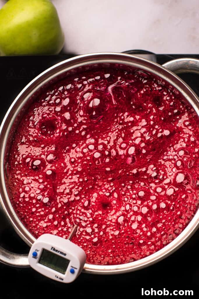 A saucepan of boiling sugar candy mixture that has been dyed red.