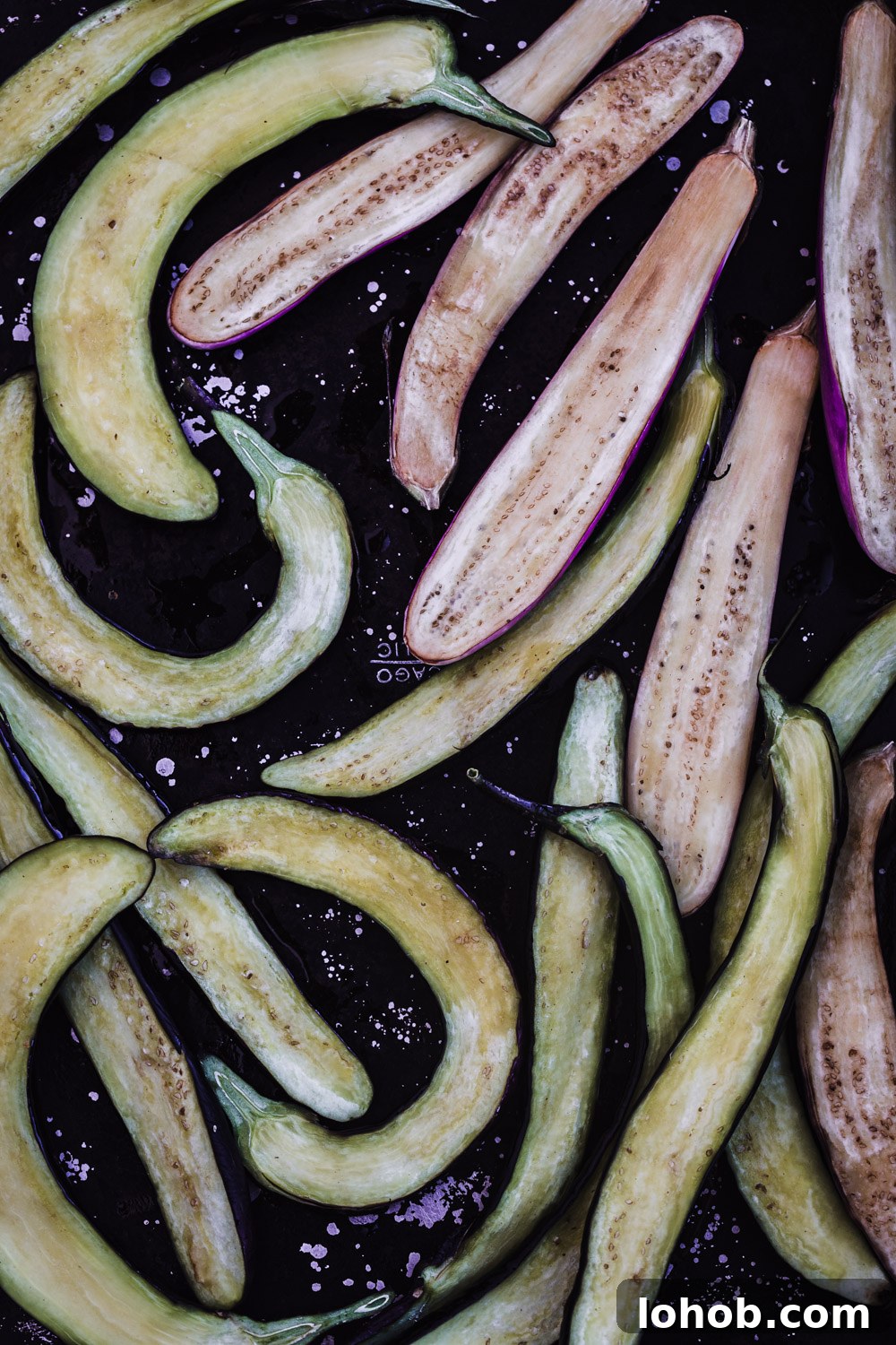 Japanese eggplant sliced in half lengthwise and coated with sesame oil.