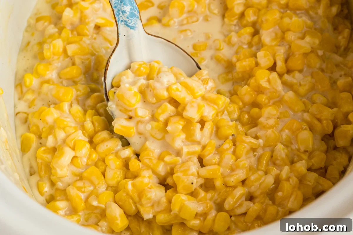 Slow cooker honey butter corn with a spoon in it.