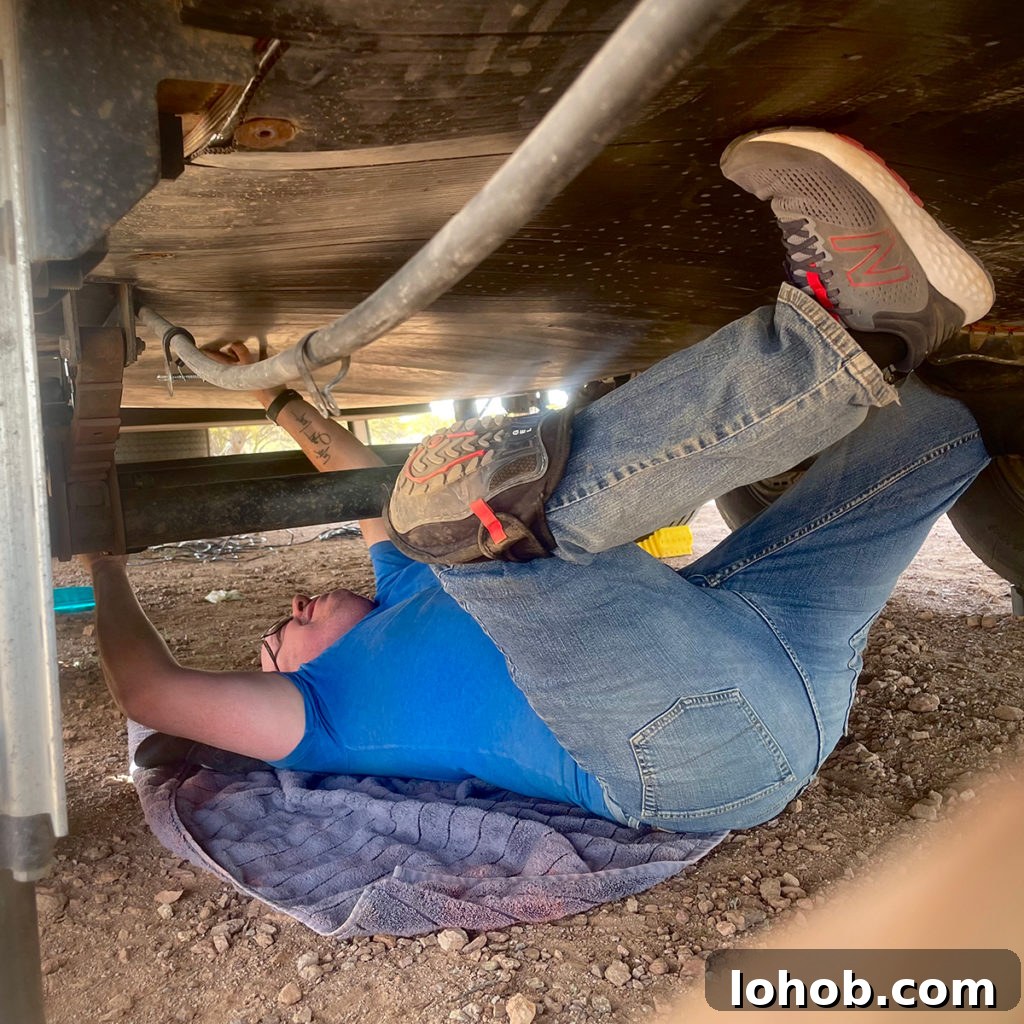 Let's Get Lost: March 2022 Travel Highlights 14 A photo of Steve laying on his back underneath our RV to make repairs.