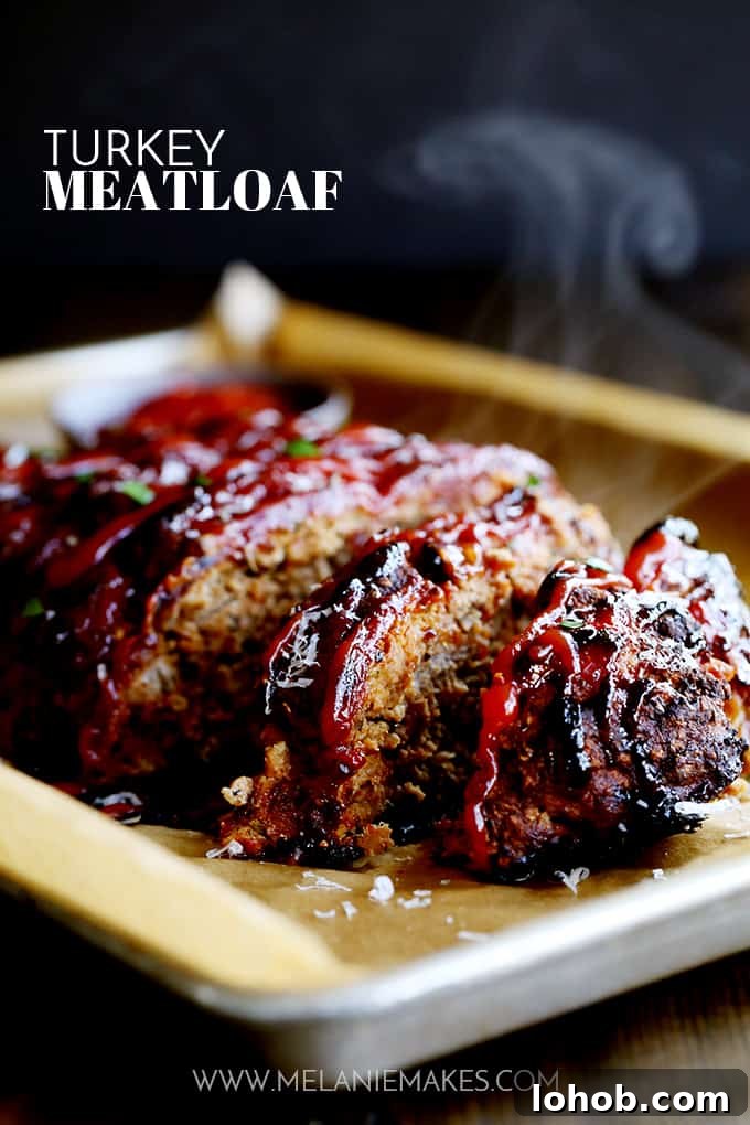 This turkey meatloaf takes just 10 minutes to prepare; seasoned with Parmesan cheese, oregano, basil and garlic. Slices of Turkey Meatloaf on a parchment lined baking sheet.