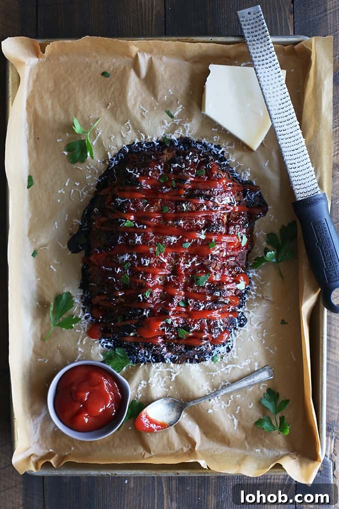 This turkey meatloaf takes just 10 minutes to prepare; seasoned with Parmesan cheese, oregano, basil and garlic. An overhead view of a Turkey Meatloaf with ketchup and Parmesan cheese.