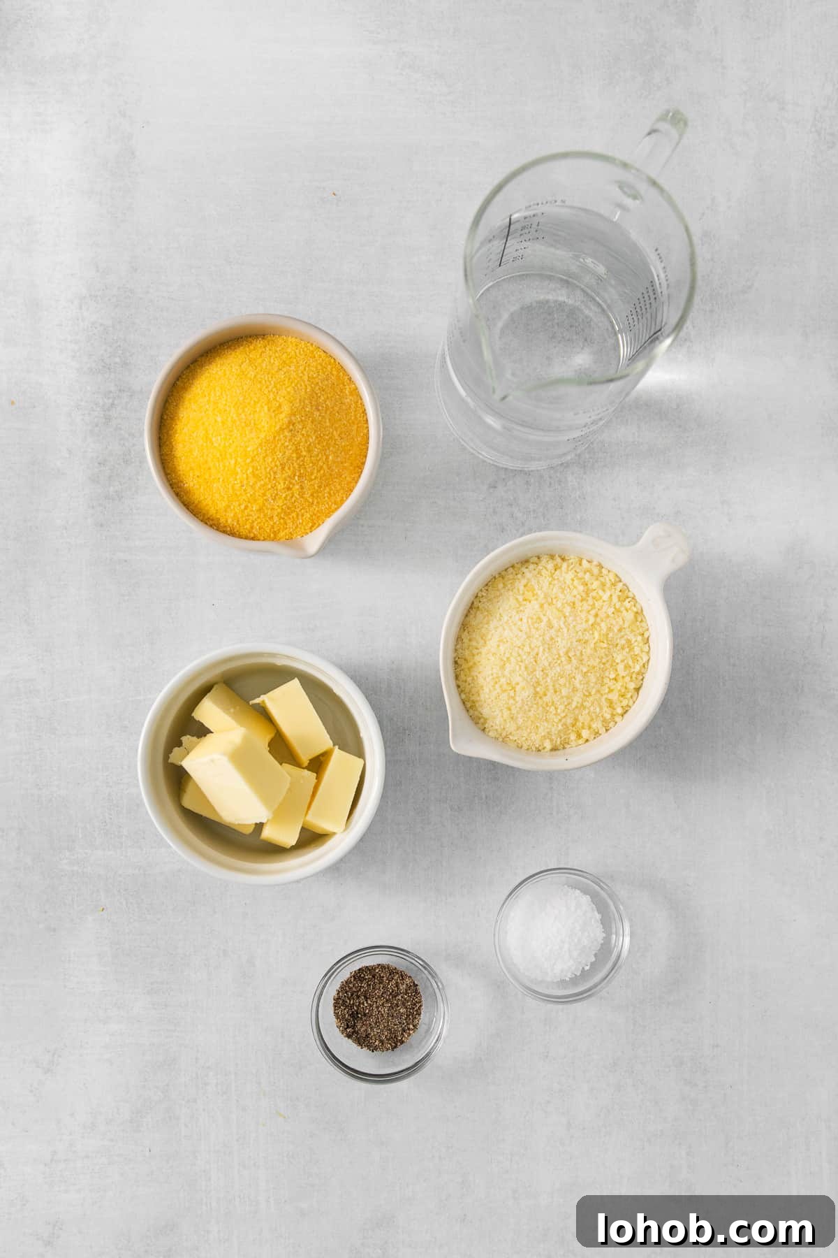 Creamy Cheesy Polenta Recipe with Parmesan 3 a table with bowls of food and a pitcher of water.
