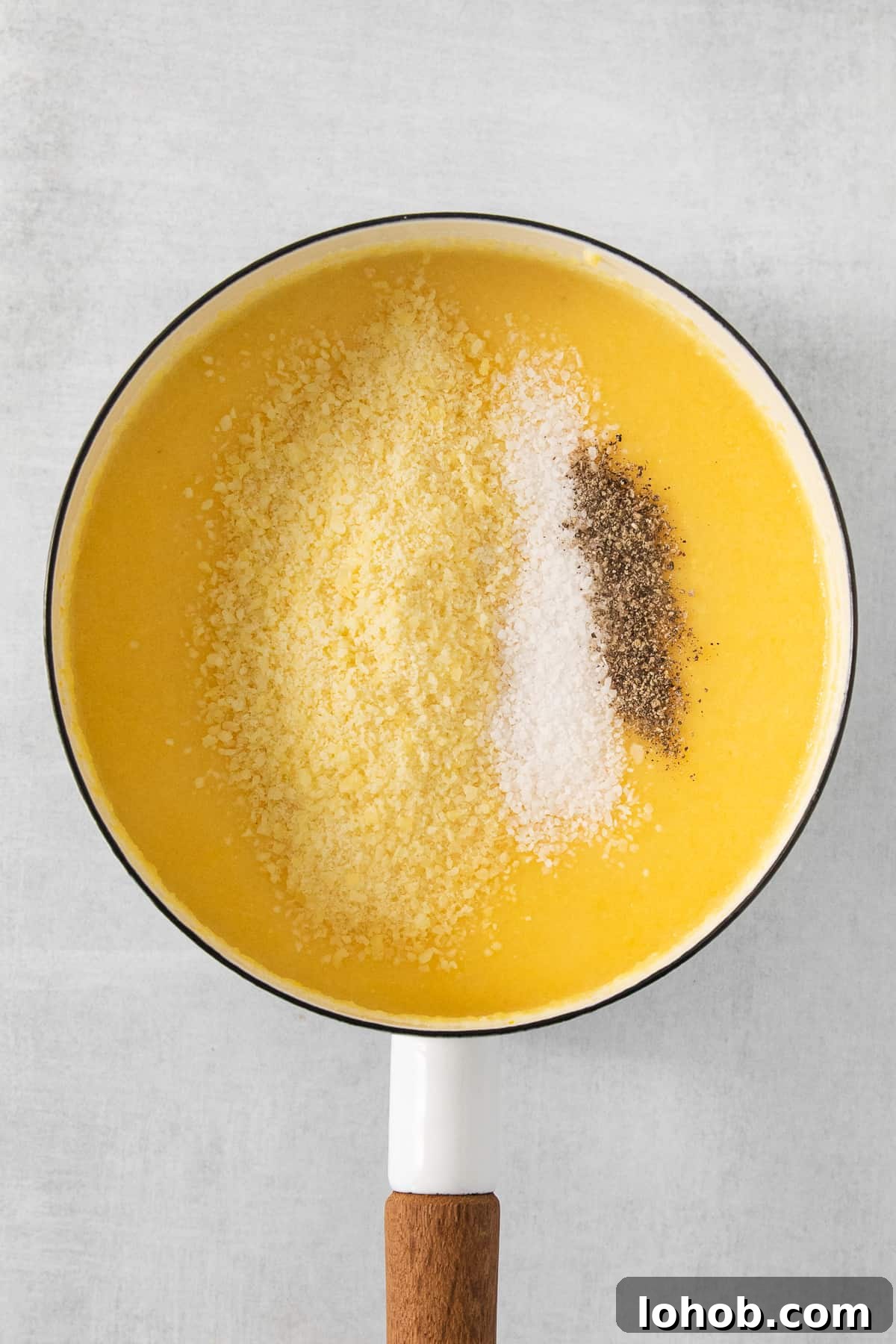 Creamy Cheesy Polenta Recipe with Parmesan 5 a bowl of soup with a wooden spoon in it.