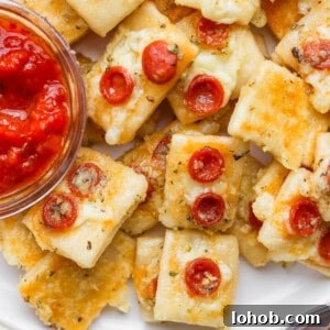 Creamy Cheesy Polenta Recipe with Parmesan 6 Close-up of mini cheese and pepperoni pizza bites on a plate with a small bowl of marinara dipping sauce.