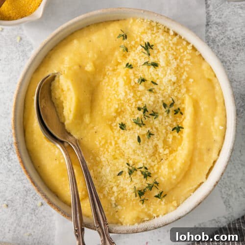 Creamy Cheesy Polenta Recipe with Parmesan 10 a bowl of mashed potatoes with a spoon in it.