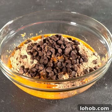 Fudgy Carrot Brownies from a Box Mix 6 Glass bowl with orange mixture, brownie mix and chocolate chips.
