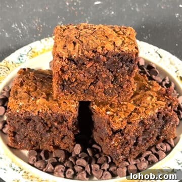 Fudgy Carrot Brownies from a Box Mix 9 Slices of fudgy brownies stacked on top of each other on a rustic dish.