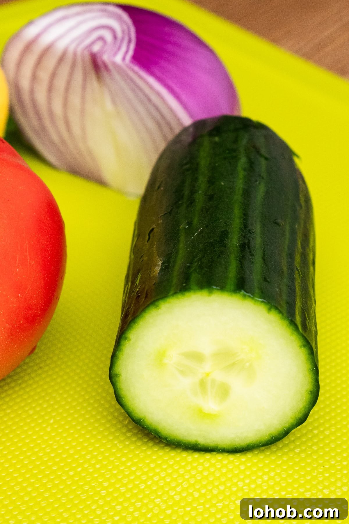 Kachumber: Tangy Indian Onion Salad 7 Quarter of cucumber on a chopping board