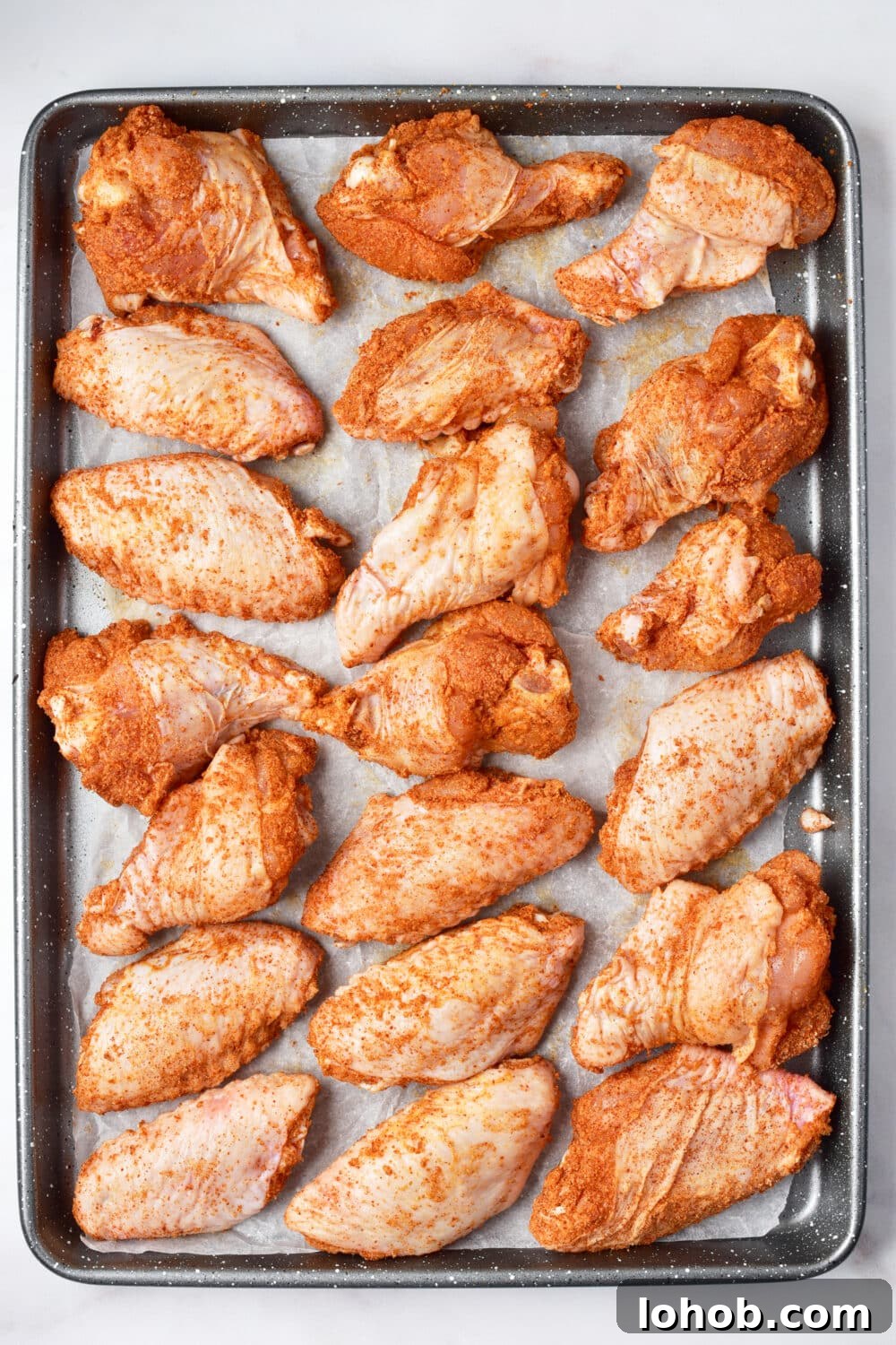 Crispy Baked Buffalo Wings Recipe 8 coated chicken wings on a baking pan