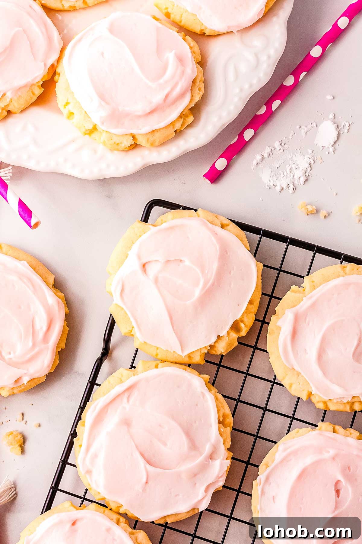Swig sugar cookies on a wire rack and on a white serving plate. 